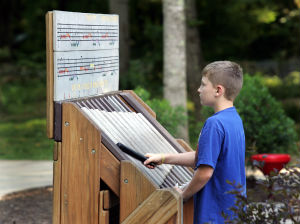Young boy playing a large xylophone in Warriors' Path State Park.
